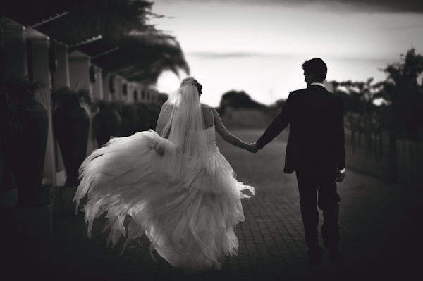 beautiful black and white photo of the happy couple walking away holding hands - wedding photo by Australia based wedding photographer Natasha Du Preez